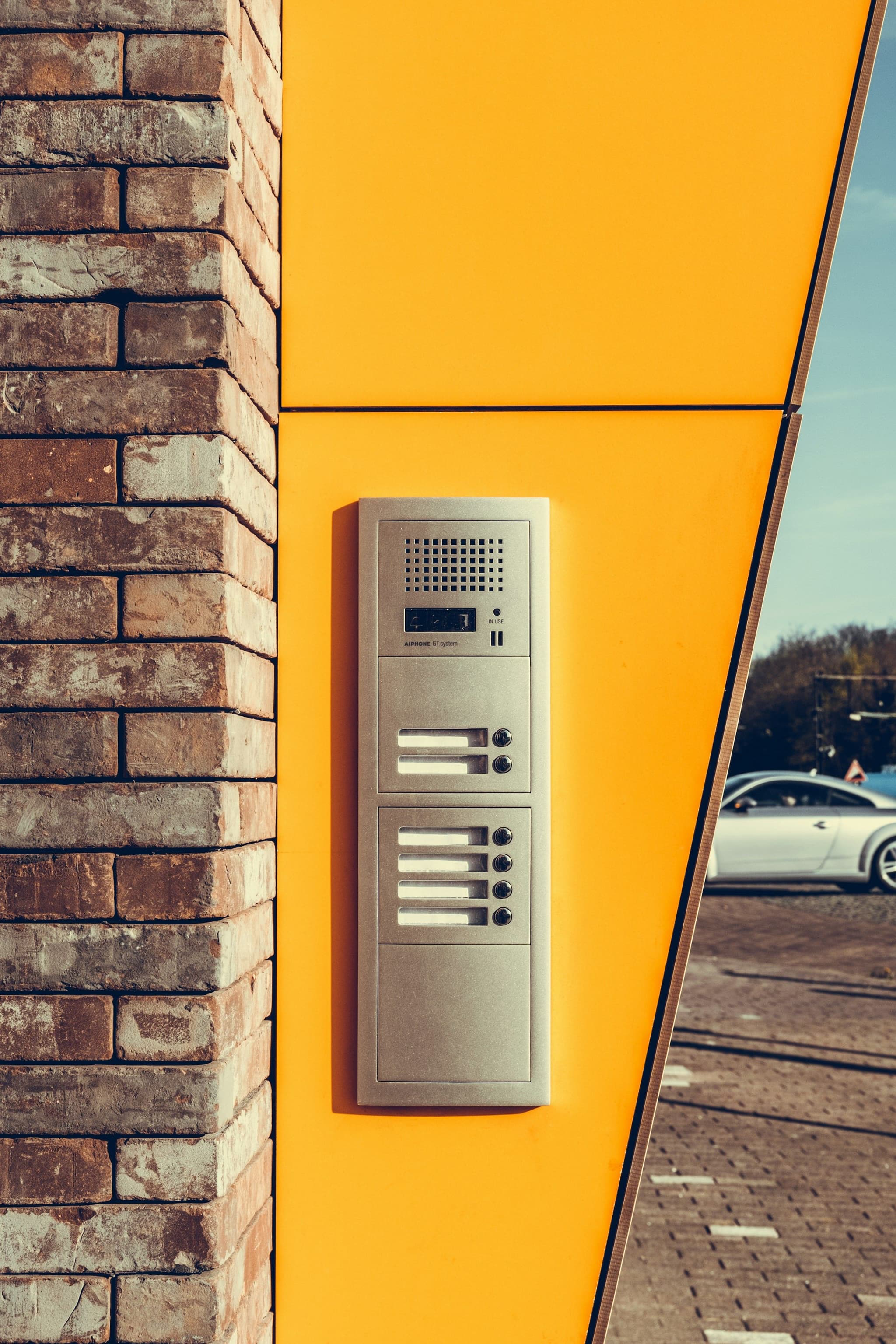 Grey alarm system sensor on a yellow wall