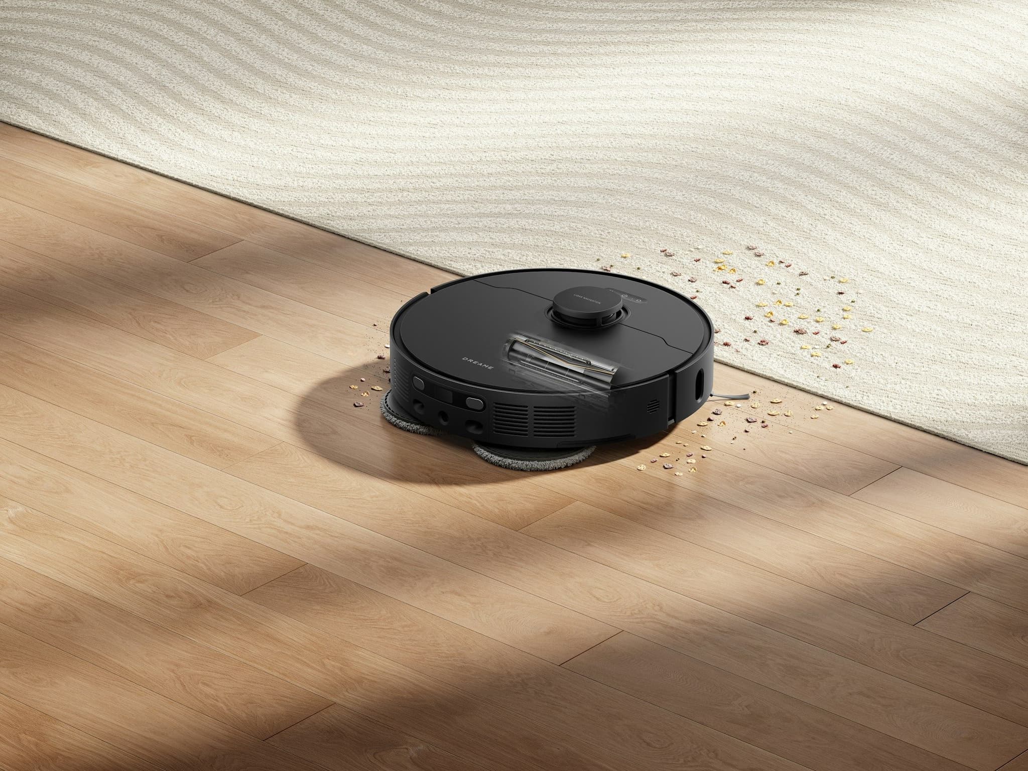 Black robot vacuum cleaning up spilled water and debris on a wooden floor